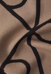 Tissu tricoté beige avec un audacieux motif abstrait noir ; texture lisse avec un étirement modéré, mettant en avant un design moderne.