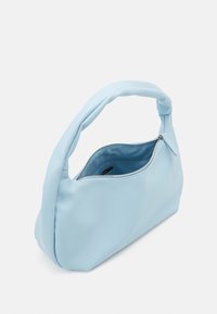 Ljusblå syntetisk handväska med en mjuk, texturerad yta, som har ett kurvat, vadderat handtag och en dragkedjeöppning.