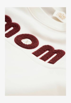 Weißer Sweatshirt mit burgunderfarbenen, strukturierten Buchstaben. Die Buchstaben sind plüschig und übergroß, mit einem kleinen, gestickten Markenlogo.