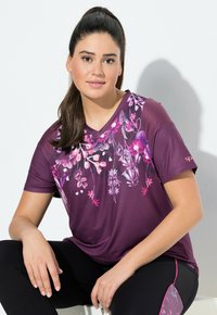 Top corto de manga corta en morado con estampado floral en rosa, blanco y morado. Presenta un diseño de cuello en V y una textura de tela ligera y suave.