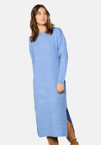 Abito lungo a maniche lunghe in maglia blu con spacchi laterali, scollatura rotonda e texture morbida. Il tessuto appare leggero e confortevole.