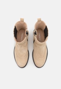Beige nubukist ankle'ide kingad elastsete külgpaneelide, lukuga ja mustade tekstuursete aktsentidega. Ümar nina ja lame kummitald.