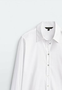 White long-sleeve shirt with a pointed collar, featuring a button-front closure and smooth, crisp texture.