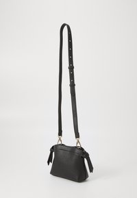 Borsa a tracolla nera in pelle con finitura testurizzata, tracolla regolabile e dettagli in metallo dorato. Presenta dettagli laterali annodati.