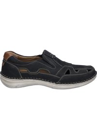 Schwarze Lederschlupfschuh mit Ausschnittdesign, kontrastierender brauner Akzent an der Ferse und weißer Naht entlang der Sohle. Weiche Textur.