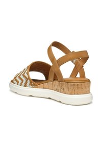 Sandalo beige con fasce incrociate, design intrecciato bianco sulla parte superiore, sottopiede in sughero e suola bianca imbottita. Fasce incrociate per una vestibilità sicura.