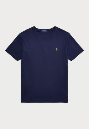 Tricou din bumbac de culoare bleu marin, cu guler rotund, mâneci scurte și un mic logo brodat pe pieptul stâng. Textură netedă, design simplu.