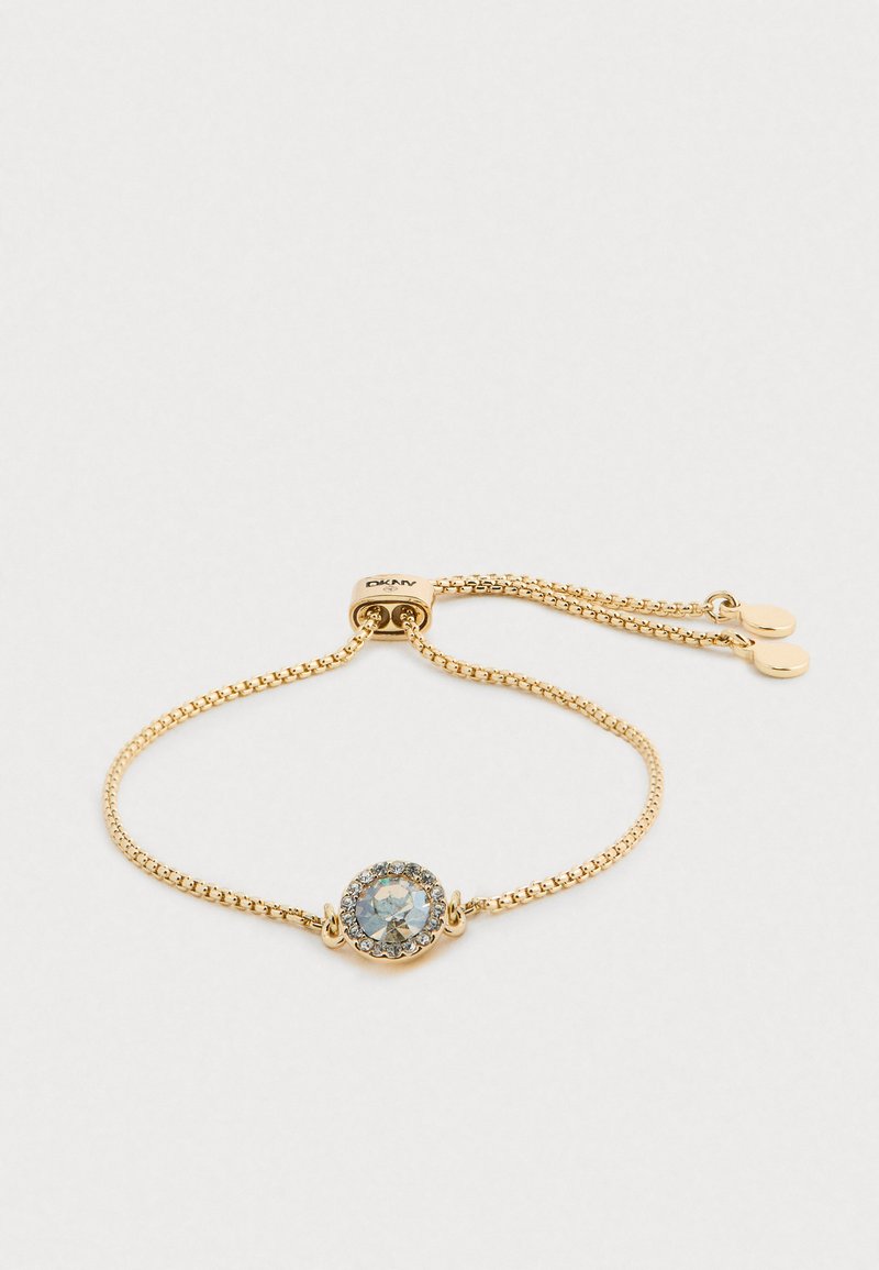 Bracciale d'oro con una fine catena, che presenta un centro circolare con una pietra trasparente circondata da pietre più piccole, con chiusura regolabile.