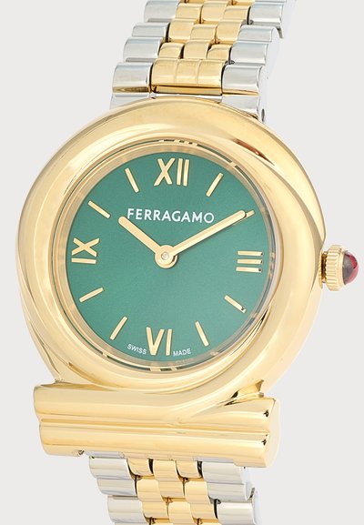 Ρολόι Ferragamo από χρυσό και ασημένιο μέταλλο με πράσινο καντράν, χρυσούς ρωμαϊκούς αριθμούς και δύο χρυστά δείκτες που δείχνουν 10:10.