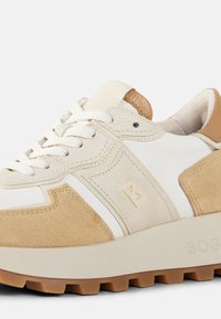 Chunky sneaker featuring a mix of textured white leather and beige suede, with a cream rubber sole and white laces. Minimal branding detail.
