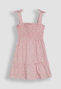 Smocked pink dress with white floral pattern, thin tie straps, and a tiered skirt. Lightweight cotton fabric, casual design.