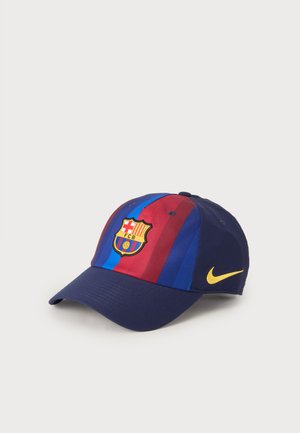Casquette de baseball avec des rayures verticales bleues et rouges, logo du FC Barcelone à l'avant, et le swoosh jaune Nike sur le côté.