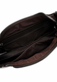 Sac à main en cuir marron avec une ouverture zippée, présentant un extérieur lisse, plusieurs compartiments et une doublure intérieure texturée.