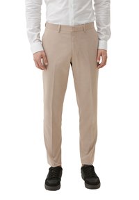 Beige dresspants met een gladde textuur en een op maat gemaakte pasvorm. Beschikt over een platte voorkant en riemlussen, gecombineerd met zwarte sneakers.
