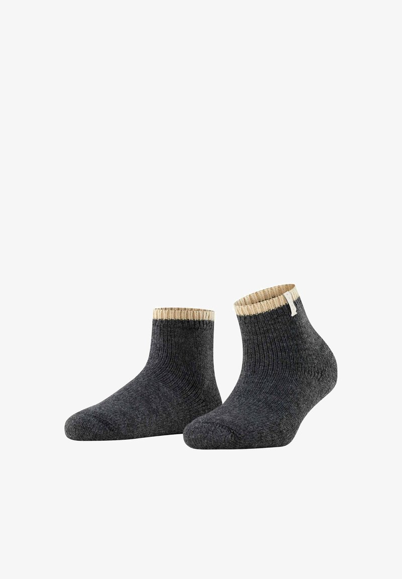 Socas cinzas escuras com uma textura canelada, apresentando uma dobra na cor creme. Design de altura até o tornozelo com uma pequena etiqueta em uma das socas.