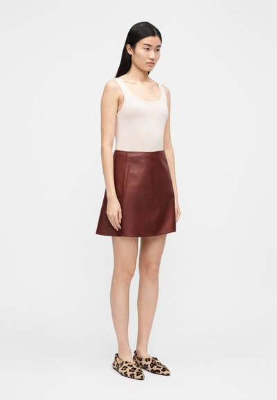 Odinė sijonas bordo spalvos, siauras liemuo, platėjanti forma. Derinama su smėlio spalvos rankovių palaidine ir bateliais su leopardų printu.