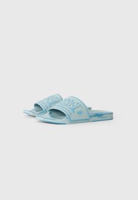 Sandales en caoutchouc de couleur bleu clair, dotées d'une large sangle avec logo en relief et d'un bord bleu contrasté, semelle plate et texture lisse.