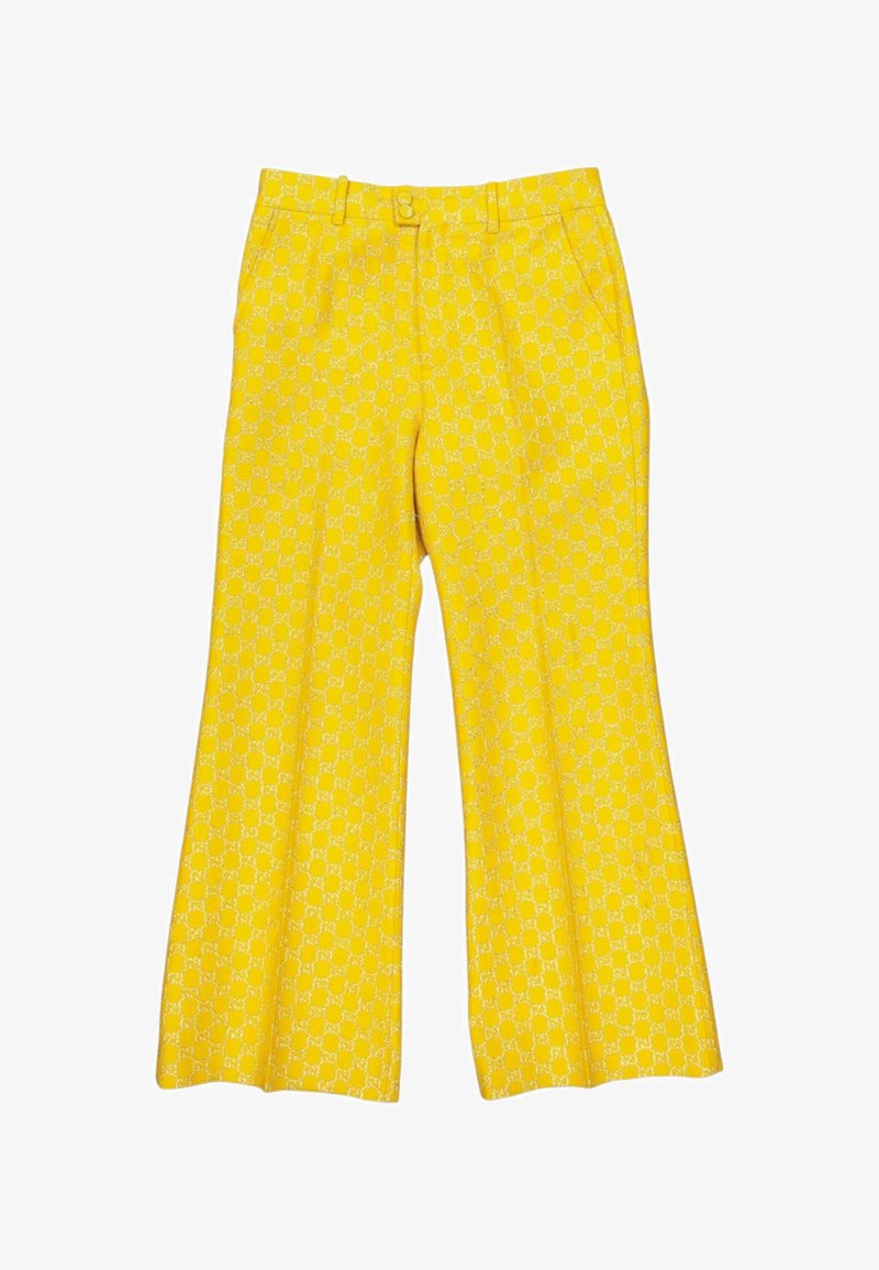 Pantalon jaune à jambes larges avec un motif géométrique blanc subtil et répétitif, bouton à l'avant, fermeture éclair, passants pour ceinture et poches latérales.