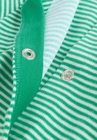 Zeleno-biele pruhované tkanivo so striebornými patentkami; hladká textúra s kontrastnými pruhmi; mäkká pletená štruktúra.