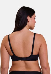 Soutien-gorge sans fil noir avec bretelles ajustables, texture lisse et fermoir à crochets ; présente un design simple sans embellissements.