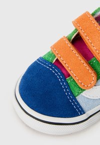Baskets colorées pour enfants en suède bleu, vert, rose et orange ; dotées de deux bandes Velcro orange et d'une semelle blanche avec des accents noirs.