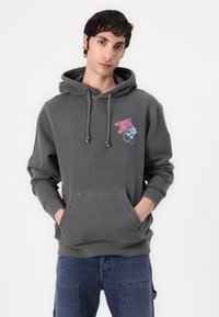 Sweatshirt cinza de algodão com um bolso canguru na frente, capuz com cordão e texto bordado. Apresenta punhos e bainha canelados.