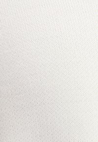 Vit stickad tyg med en fin textur, med jämnt fördelade stygn. Slät yta, lätt och flexibel i utseende.