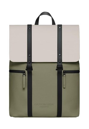 Rucksack mit einem gefalteten beigefarbenen Klappdeckel, schwarzen verstellbaren Riemen und einem olivgrünen Korpus. Verfügt über zwei Reißverschlussfronttaschen und ein Logodesign.