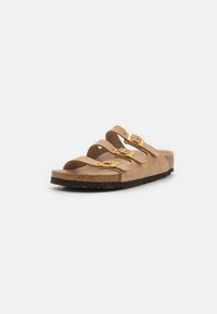 Sandal de camurça castanha com três correias ajustáveis com fivelas douradas, uma palmilha de cortiça e uma sola de borracha preta texturizada.