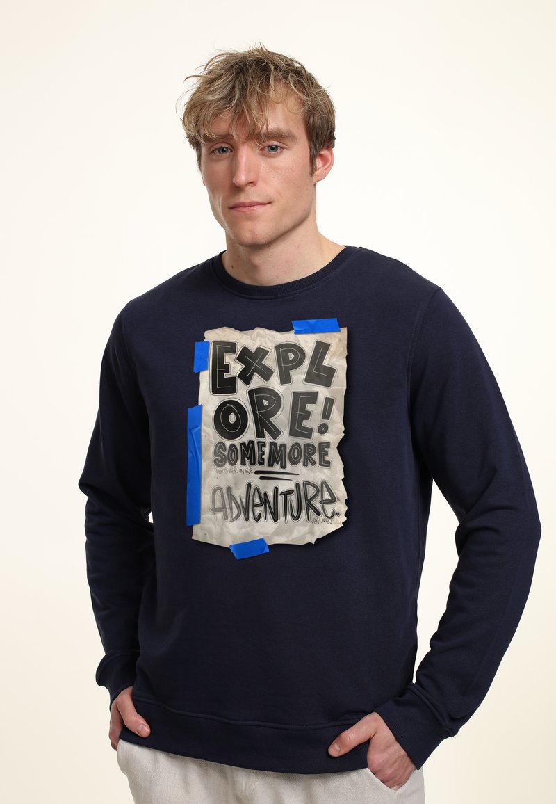 Felpa blu navy con un design grafico testurizzato sulla parte anteriore, caratterizzato da testo in stile scrittura a mano attaccato al tessuto.
