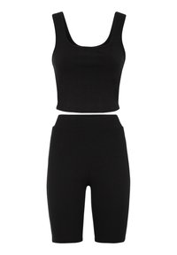 Schwarzes, geripptes Zweiteiler-Set mit einem gefütterten Tanktop mit breiten Trägern und hoch taillierten Radlerhosen. Weiche Textur und enganliegende Silhouette.