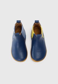 Botas de tobillo de cuero azul con una textura suave, que presentan acentos en amarillo y azul claro en los laterales y una suela de goma.