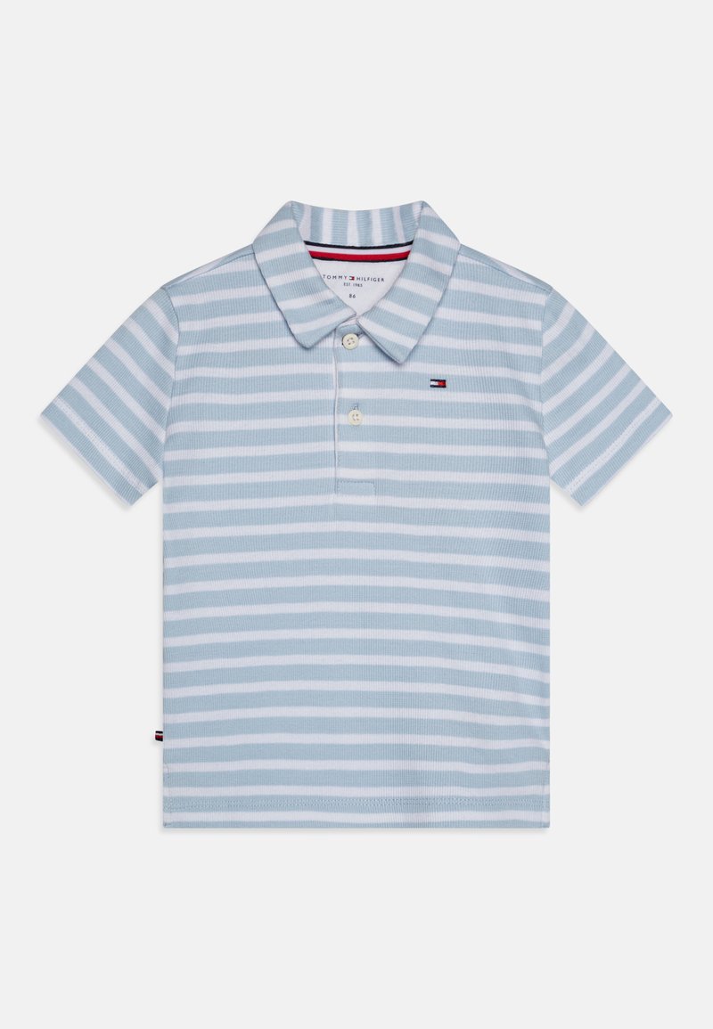Lyseblå polo skjorte med vertikale hvite striper, krage og to knapper foran. Har en liten brodert logo på venstre bryst.