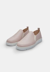Světle růžové slip-on boty vyrobené z hladké kůže s elastickými bočními panely a bílými texturovanými gumovými podrážkami. Zpevněné zadní poutka.