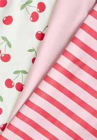 Trois tissus pliés présentant un imprimé cerises sur fond blanc, un uni rose clair, et un rose avec des rayures horizontales rouges.