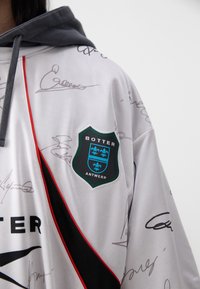 Gray hoodie with a white body covered in signatures. Features a black and red diagonal stripe, and a shield logo with "BOTTER ANTWERP."