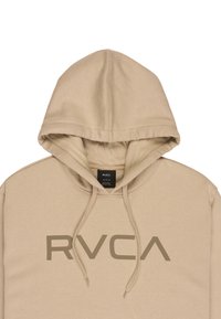 Beżowa bluza z kapturem z przednią kieszenią typu kangur, regulowanym sznurkiem w kapturze oraz dużym ciemnobeżowym logo "RVCA" na piersi. Gładka faktura.