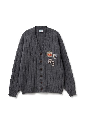 Šedý žebrovaný kardigan s výstřihem do V, hnědými knoflíky a vyšívanými nášivkami zobrazujícími korunu a číslo 83. Texturovaná pletená látka.