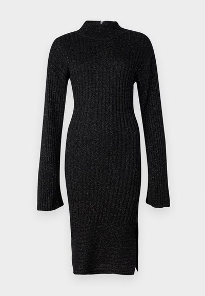 Juoda raukinėta megztinė su ilgomis rankovėmis, aukštu kaklu ir tekstūruotu audiniu, turinčiu subtilių metalinių gijų, šone yra iškirpimas.