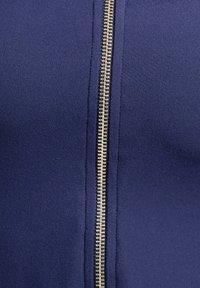 Navy blue fabric top with a gold zipper at the center, featuring a smooth texture and fitted design.