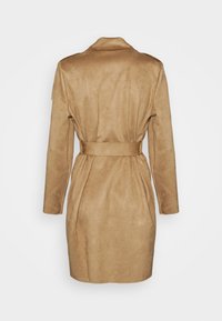 Beżowy płaszcz z długim rękawem wykonany z miękkiej, teksturowanej tkaniny. Posiada dopasowaną talię z pasującym paskiem oraz wycięty kołnierz.