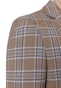 Marynarka w kratę w odcieniach brązu i niebieskiego, charakteryzująca się strukturalną tkaniną, wyrazistymi klapami i dopasowanym krojem. Zbliżenie na szczegóły w okolicy ramienia.