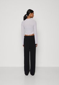 Vero Moda Petite VMEASY WIDE PANTS LEO PRINT - Pantalon classique - black