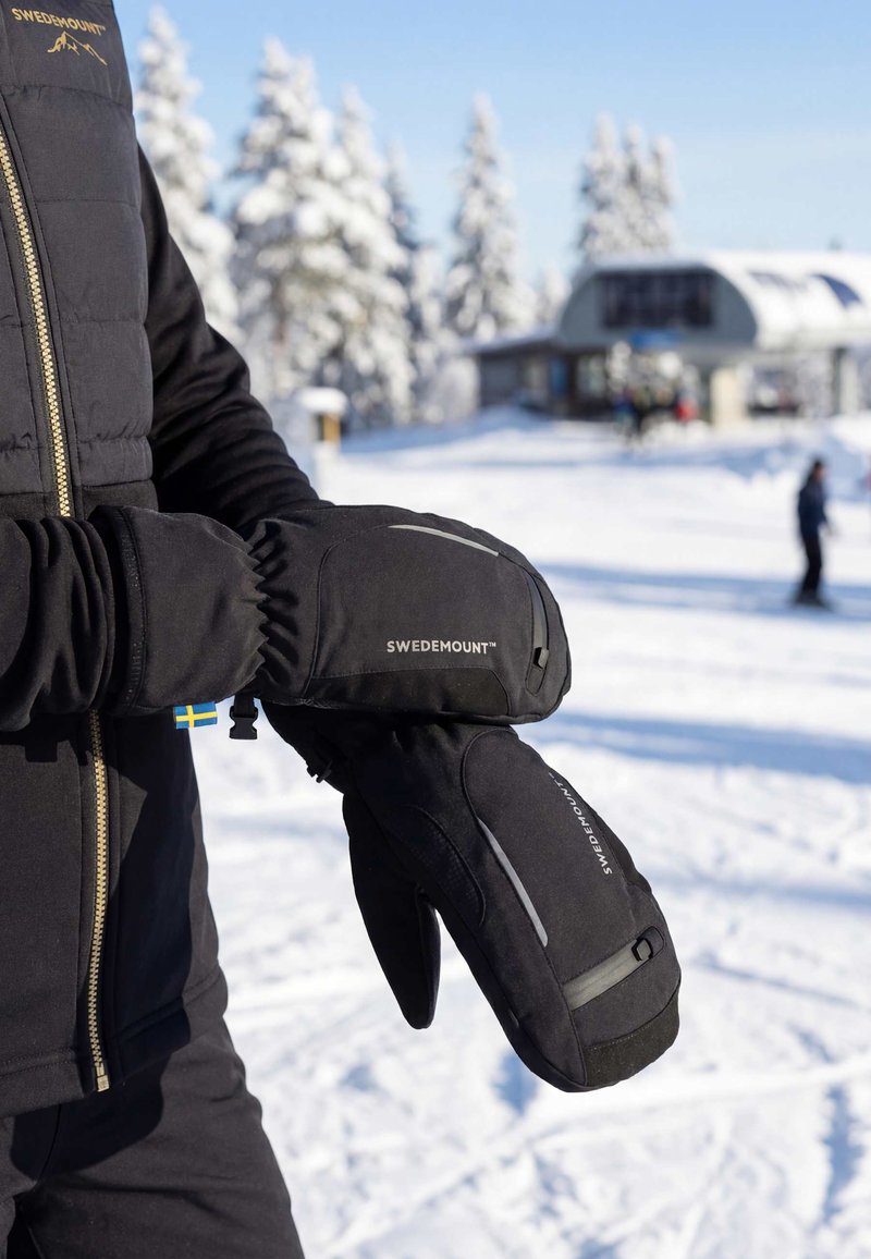 Black insulated mittens with a sleek design, featuring a logo and reflective accents. Constructed from durable, weather-resistant material.