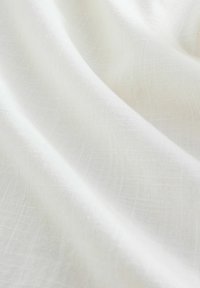 Balta medžiaga su minkšta, lygi tekstūra ir subtiliu, tinklelio panašiu raštu. Šviesi, lengva išvaizda, tinkama įvairiems tekstilės panaudojimams.