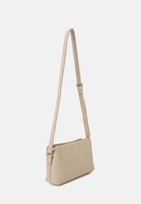 Borsa a tracolla rettangolare beige con tracolla regolabile e chiusura con zip, esposta su uno sfondo bianco uniforme.