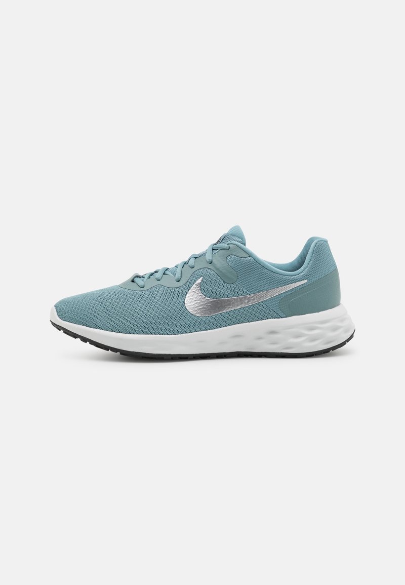 Chaussure de course Nike bleu clair avec semelle blanche rembourrée, logo Nike swoosh argenté et semelle extérieure noire à relief, vue de côté gauche.