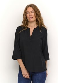 Czarna, luźna bluzka z dekoltem w serek, 3/4 rękawami i prostym dołem. Wykonana z gładkiego materiału o minimalnej teksturze.