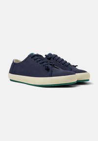 Marineblauwe canvas sneakers met een ronde neus, witte rubberen zool en contrasterende teal accenten op de tong en zool. Vetersluiting.