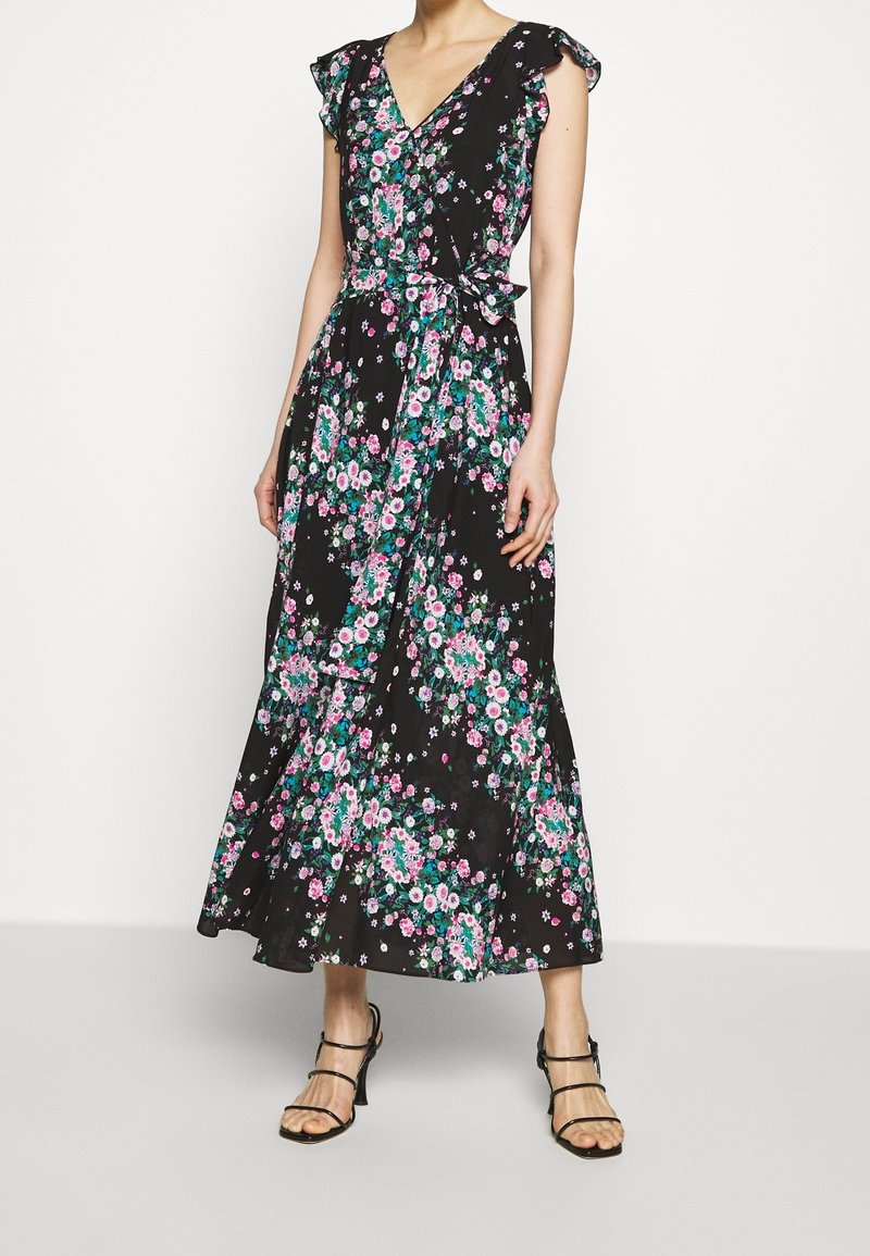 Blommig omlottklänning i svart, med volangärmar, V-ringning och knytmidja. Ljusrosa och gröna blommönster pryder tyget.